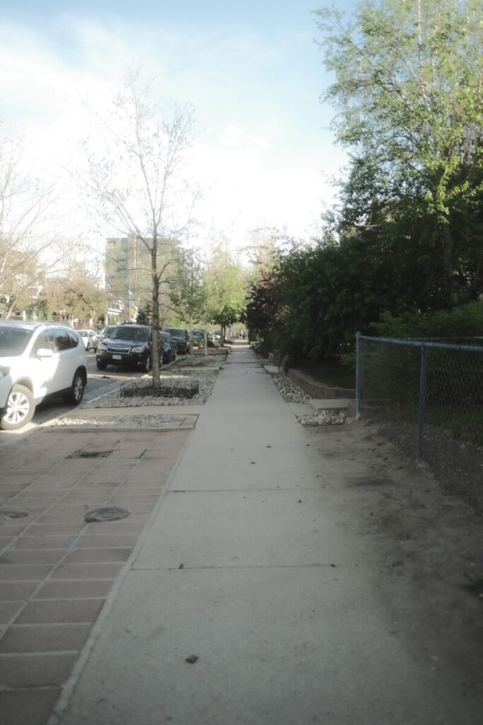 a sidewalk with cars parked on the side of it